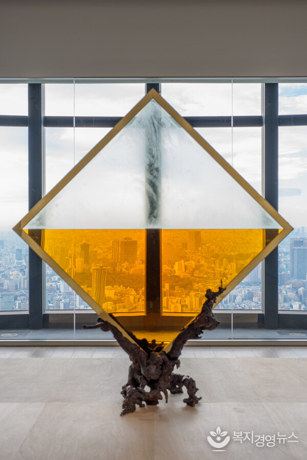 Wada Reijiro "MITTAG" 2025 Glass, brass, bronze, and brandy 238 x 212 x 79 cm Production Support / Courtesy: SCAI THE BATHHOUSE, Tokyo Installation view: "Roppongi Crossing 2025: What Passes Is Time. We Are Eternal.", Mori Art Museum, Tokyo, 2025-2026 Photo: Takehisa Naoki Photo courtesy: Mori Art Museum, Tokyo